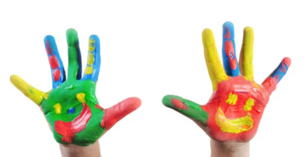 Mani bambino dipinte con colori sgargianti e smile